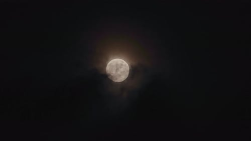 Ethereal Full Moon Behind Ominous Clouds in the Night