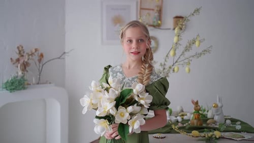 Girl with Flowers in a Green Dress at Easterthemed Table Spring Decorations and Floral Style Child