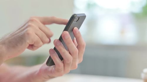 Close up of Man Browsing Internet on Smartphone