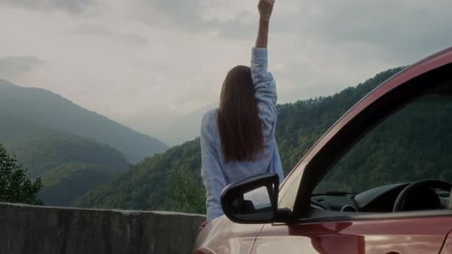 Pretty Girl is Standing Next to the Car Near the Hood Female's Road Trip to Nature Mountains
