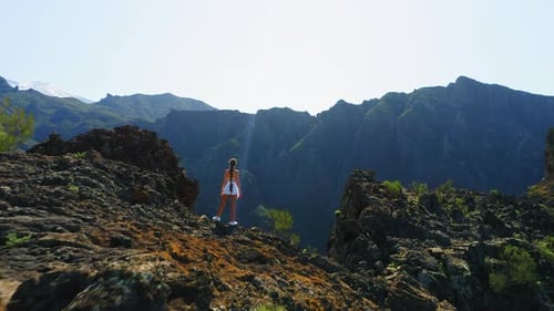 Une belle femme en bonne santé profite de la nature au sommet de la montagne