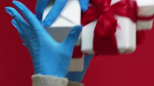 Hands in Gloves Presenting Wrapped Birthday Gifts