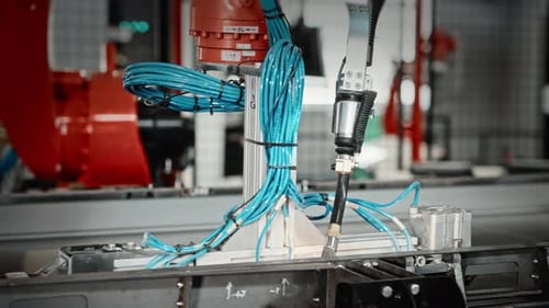 Le robot dispose les câbles en toute sécurité sur le châssis Un robot guidé avec précision organise le faisceau de câbles sur un appareil industriel