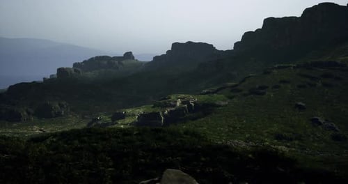 Mountainous Landscape with Rocky Formations and Greenery During Dusk