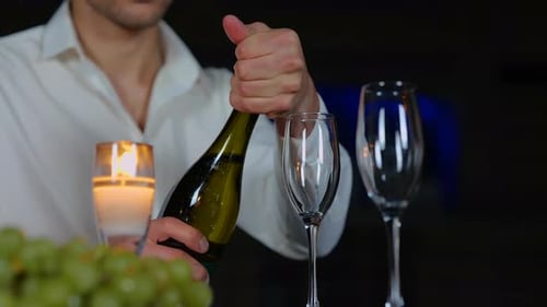 Young Adult Opens Champagne Bottle for Romantic Celebration