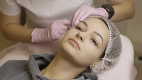 Cosmetologist Administers Facial Injection to Young Woman