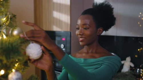 Close Up Happy African American Woman Decorating Christmas Tree at homeSmiling New Year Holiday
