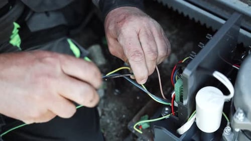 Man Connecting Wires in Electrical Device Close Up