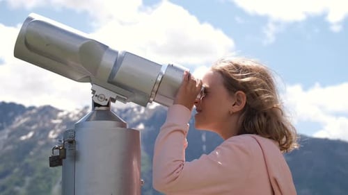 Girl Looking Through Binoculars at Mountain View