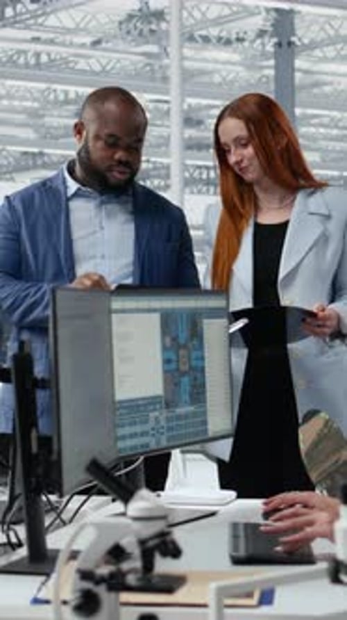 Vertical Video Portrait of Smiling Engineering Team Examining Semiconductor Substrate