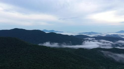 Drone panning a beautiful scenery of the high mountains on the cloud at sunrise