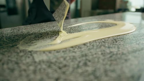 Tempering chocolate production of chocolate candies - pastry chef mixes melted chocolate