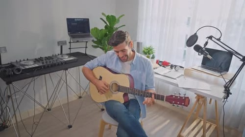 Man Plays Acoustic Guitar in Home Studio