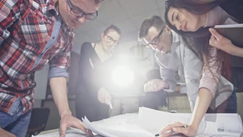 Architektenteam arbeitet gemeinsam an einem Gebäudeplan in einem Büro