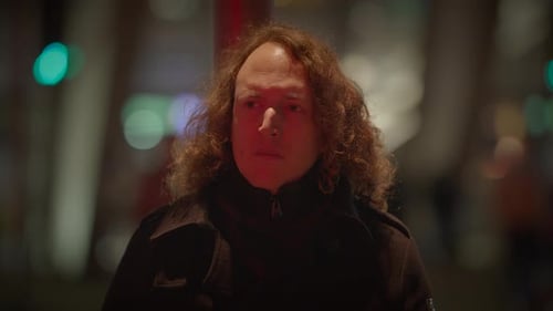 A Contemplative Man with Curly Hair in a City at Night Lost in Thought and Solitude