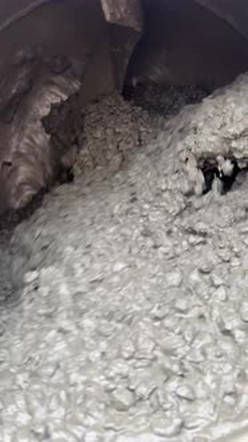 Gray Cement Mixture Cascading in Industrial Mixer