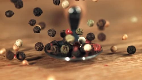 Colorful Peppercorns Falling Onto Silver Spoon Close Up