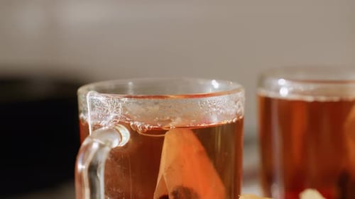 Nahaufnahme von heißem Tee in einer Glasschale mit Teebeutel und Dampfaufgang
