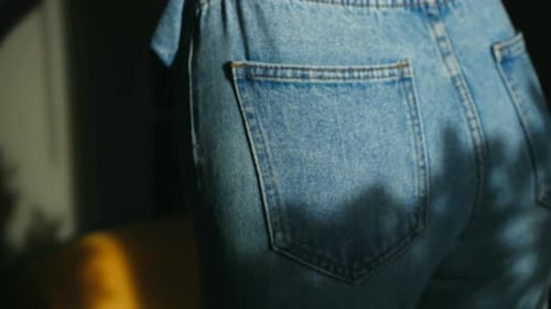 Woman Putting On Jeans in Bright Light