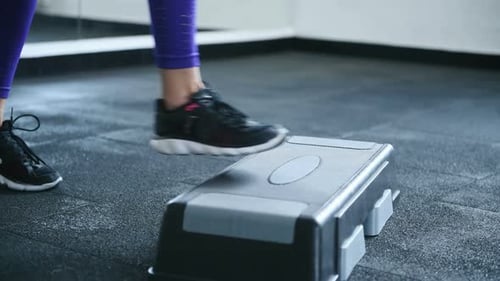 Close up view of woman's legs that doing fitness exercise indoors