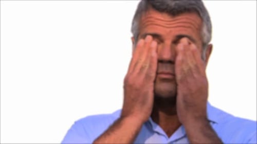 Man puts on glasses and smiles into camera