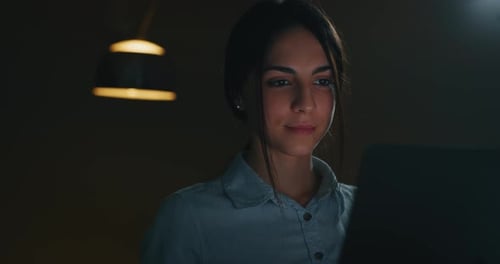Slow motion close up of a young beautiful business woman is working with a computer in the evening