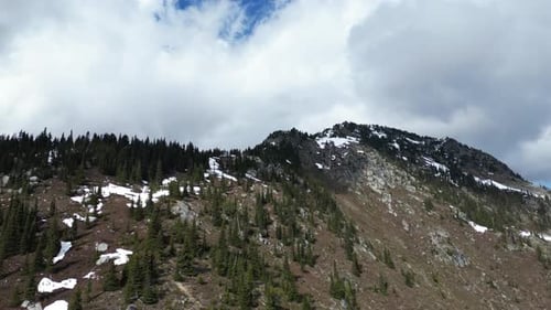 Canadian Rocky Mountain Peak, trees and clouds. British Columbia, Canada.