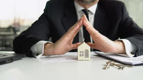 Senior Businessman Covering and Protecting Home with His Hands Property and Real Estate Insurance