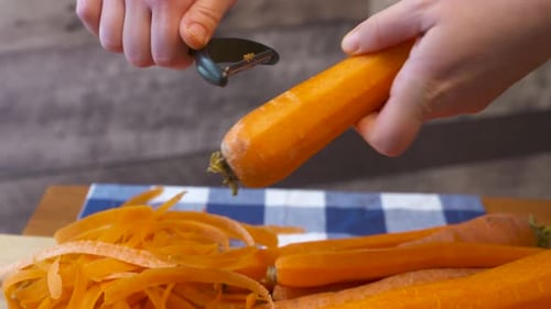 Fresh Carrots Being Peeled with Vegetable Peeler