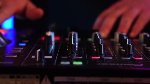 DJ jouant de la musique lors d'une fête. Gros plan des mains sur la manette, la table de mixage et la plaque tournante