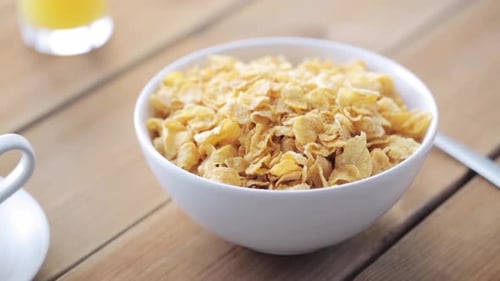 Bowl of Cornflakes with Sugar and Orange Juice