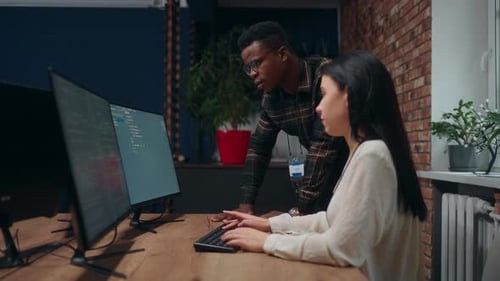 Two Programmers Talking in Office Discussing New Project Woman and Man Multiethnic Coworkers