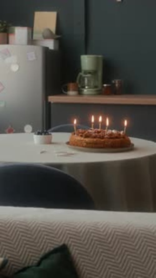 Vertical of Birthday Cake with Burning Candles in Cozy Kitchen Interior