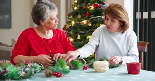 Women Crafting Christmas Wreaths at Home Together