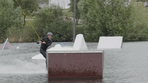 Man Practicing Tricks on Wakeboard at Cable Park