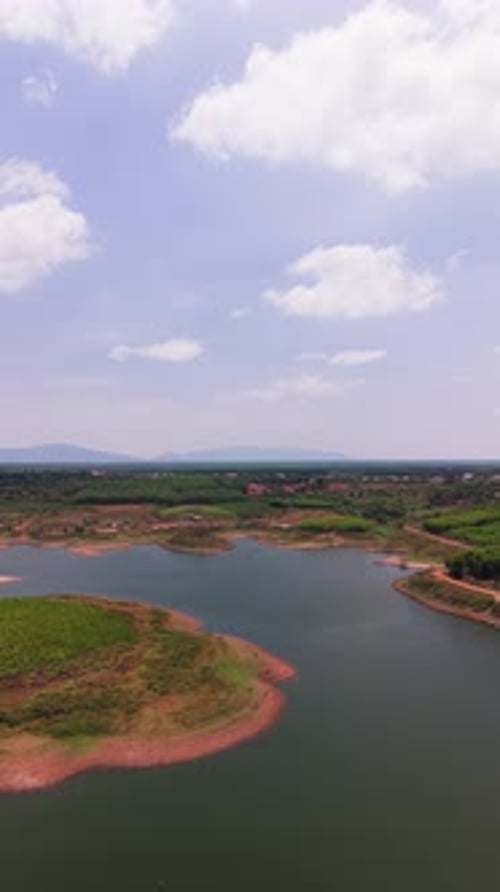 Explorez le lac Ray au Vietnam vu d'en haut. Le soleil illumine l'eau. Collines et verdure