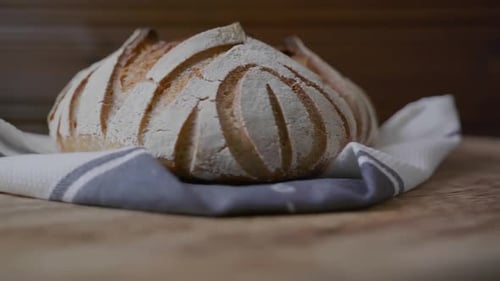 Low angle view of a fancy artisan loaf of bread presented on a spinning wooden table.