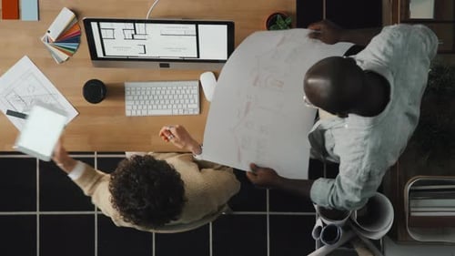 Businesswoman Discussing Blueprint with Colleague