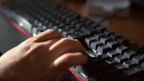 Uma mão usando as teclas de seta do teclado para o jogo