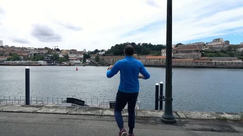 Successful Male Jogger Raising Arms Near River in City, Super