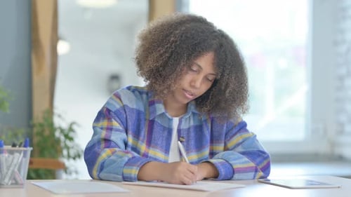 Young Adult Writing at Desk Indoors