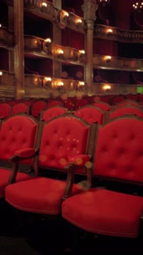 Ornate Theater with Red Velvet Seats and Floating Light Particles