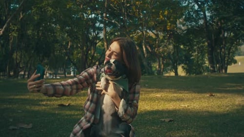 Young Woman Taking Selfie with Dog in Park