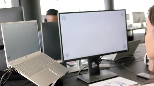 Working in office, person using laptop and desktop monitor for business tasks, copy space
