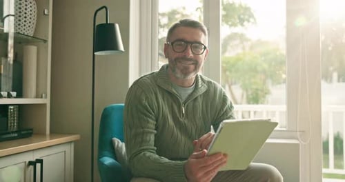 Man using tablet in sunny living room