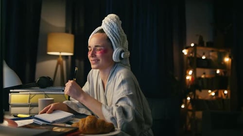 Woman in robe singing into pen at desk