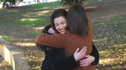 affection, friendship - happy friends hug each other at the park
