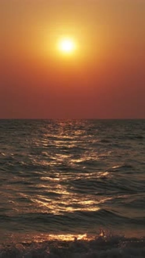 Sunset over ocean with dramatic clouds at dusk