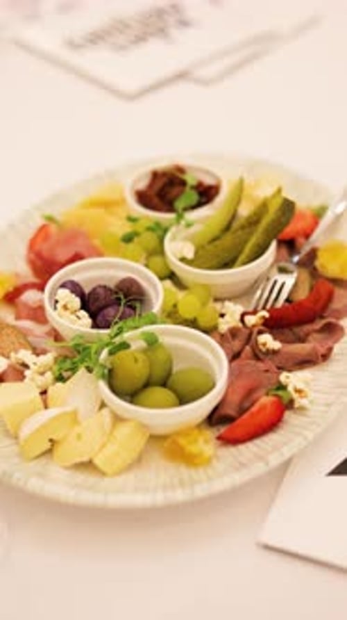 Planche de charcuterie gastronomique avec fromage, viande, olives et fruits