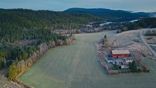 Luftaufnahme einer traditionellen roten Scheune und eines Gehöfts in einer ländlichen Landschaft